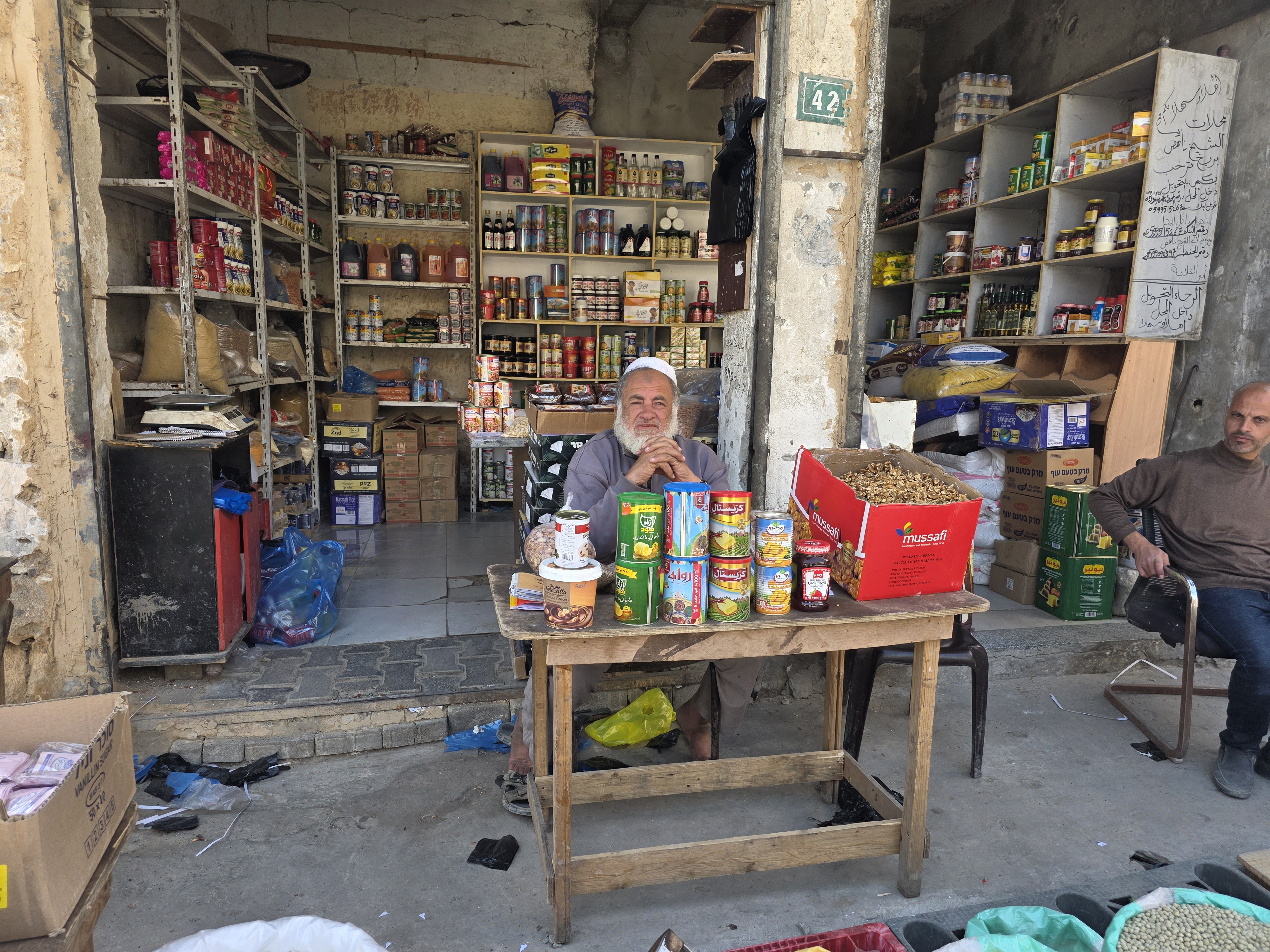 Nahed Barbakh, 60, shop owner and trader, sits at a table in front of his store