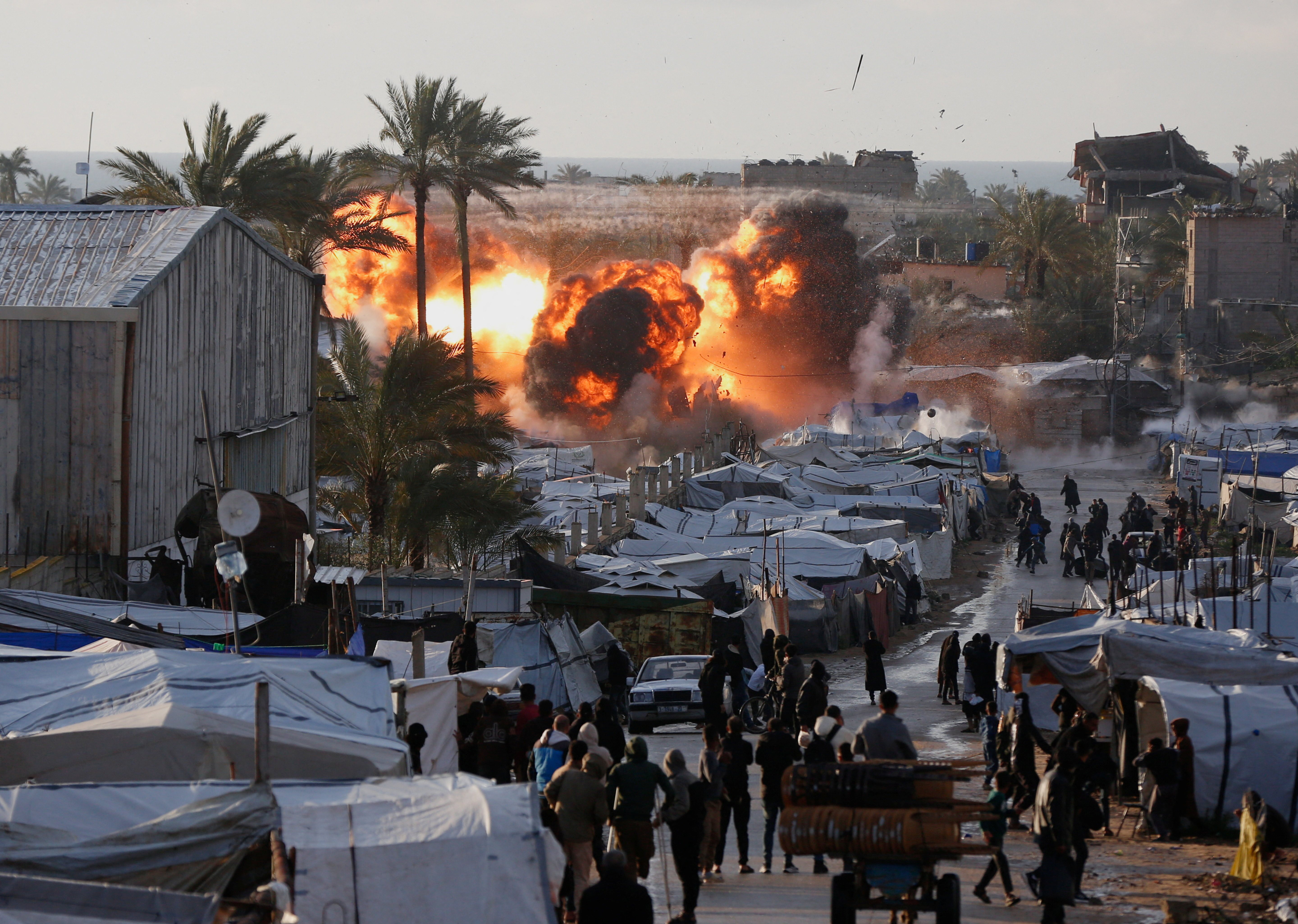 Smoke and flames rise following an Israeli strike near a tent camp sheltering displaced Palestinians in Deir al-Balah, central Gaza Strip, March 25, 2026. The Israeli military ordered camp to evacuate before the strike, according to residents. REUTERS/Stringer.