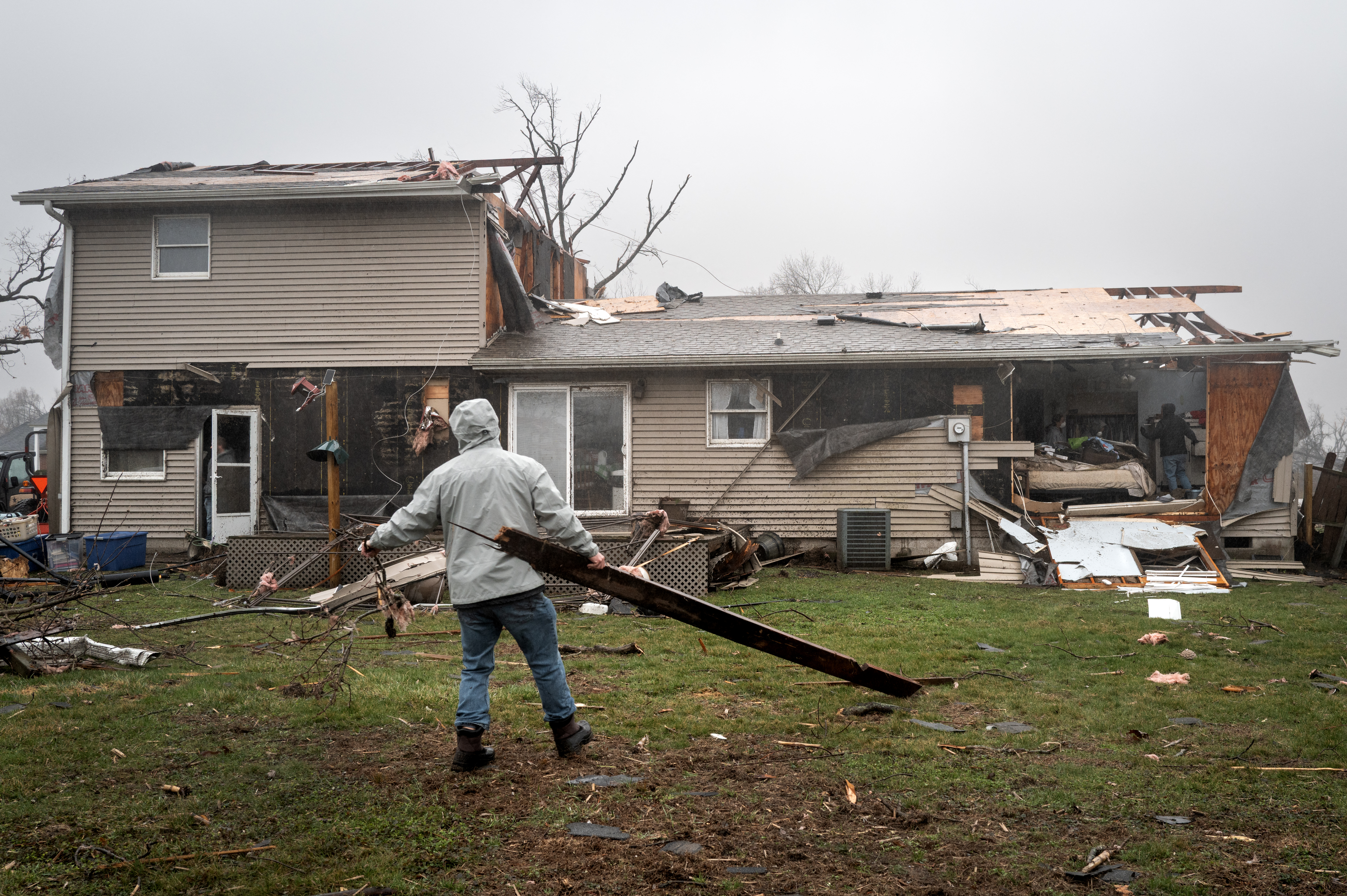 LAKE VILLAGE, INDIANA - MARCH 11: Mike Dresbaugh helps clean up debris from around a home after a tornado passed through the small town yesterday, on March 11, 2026 in Lake Village, Indiana. Several tornadoes passed through Indiana and Illinois yesterday, leaving behind a path of destruction and at least two people dead in Lake Village. Scott Olson/Getty Images/AFP (Photo by SCOTT OLSON / GETTY IMAGES NORTH AMERICA / Getty Images via AFP)