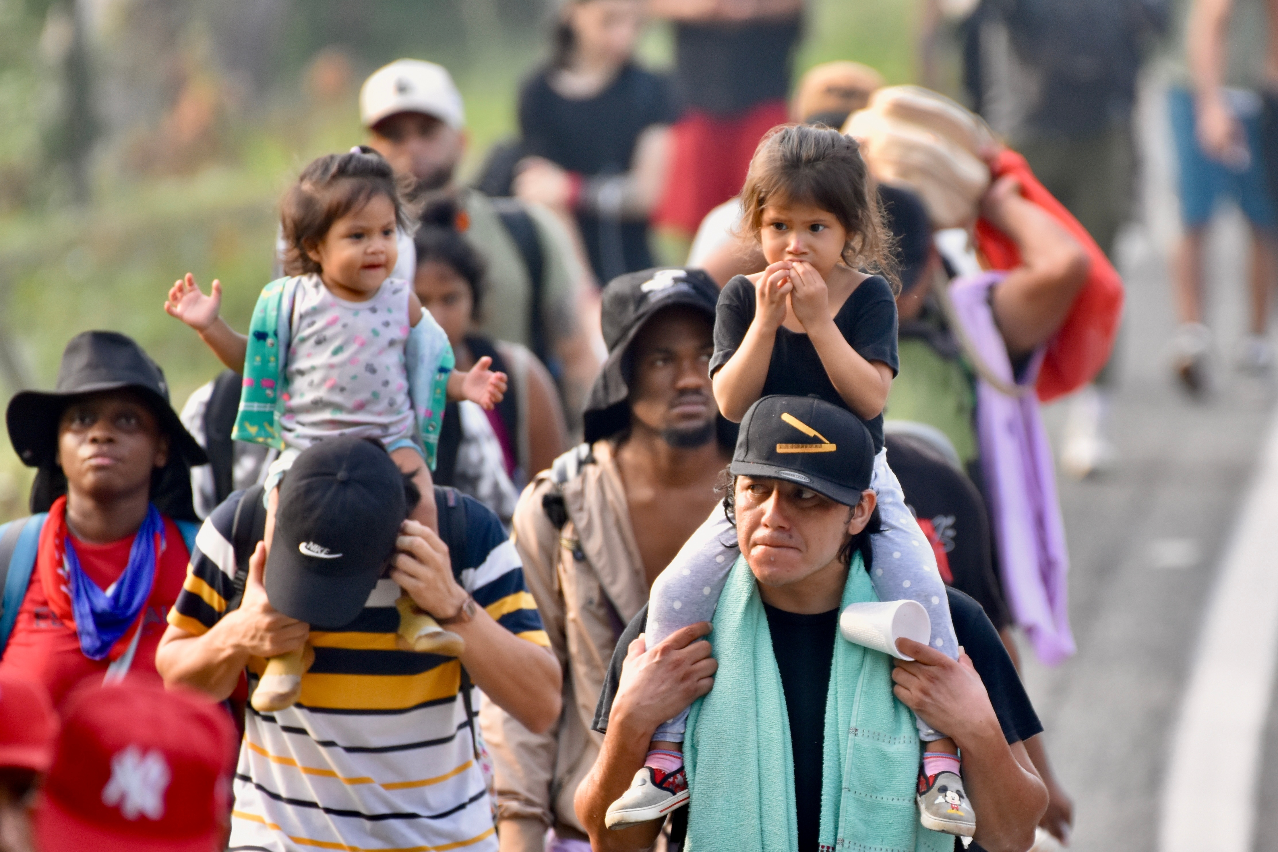 Migrants, some carrying children, walk on the highway through the municipality of Huehuetan, Chiapas state, Mexico, Wednesday, March 25, 2026, after leaving Tapachula the previous night. (AP Photo/Edgar H. Clemente)