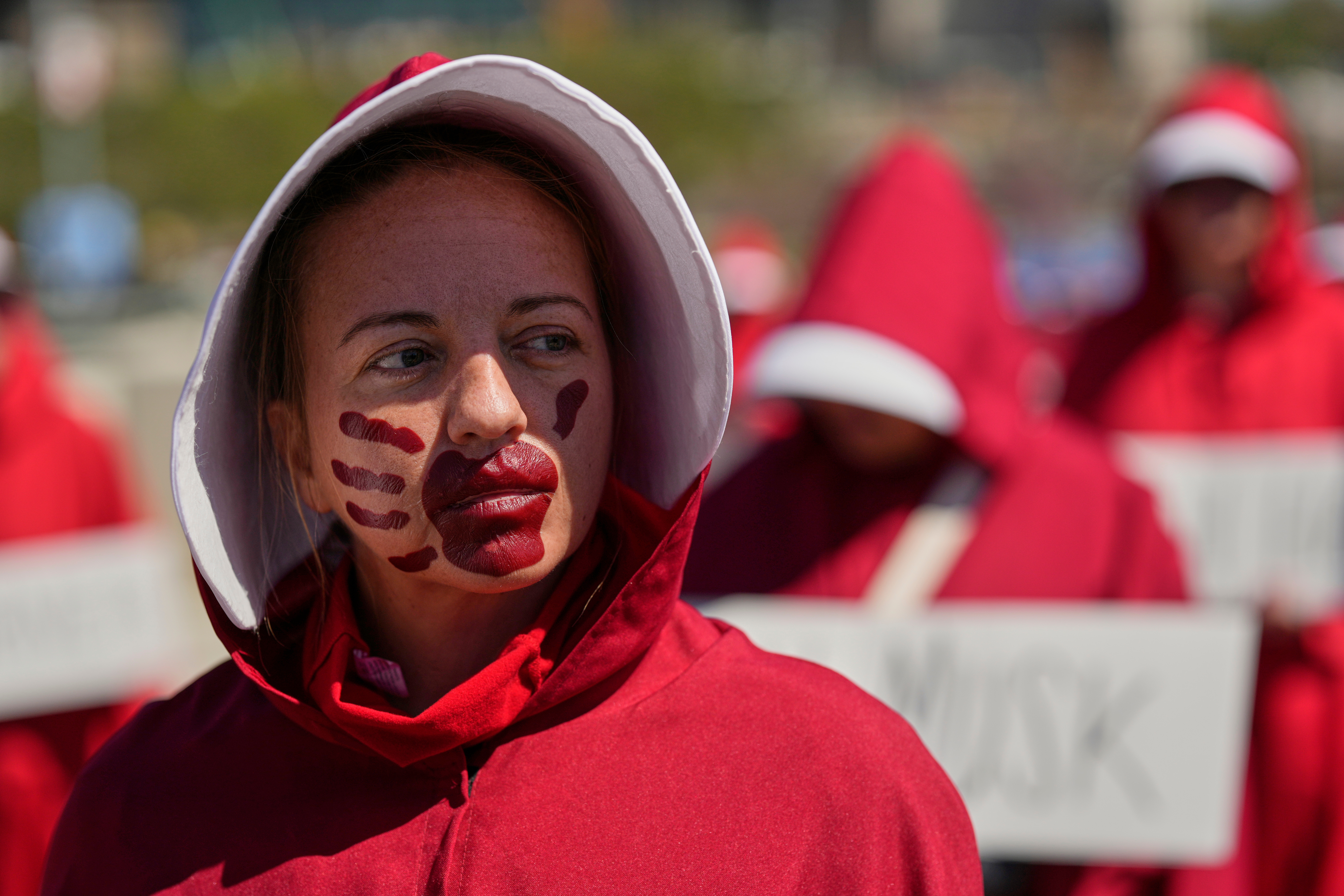 Sara R., dressed as a character from the TV series, "The Handmaid's Tale," demonstrates during a "No Kings" protest Saturday, March 28, 2026, in Nashville, Tenn. (AP Photo/George Walker IV)