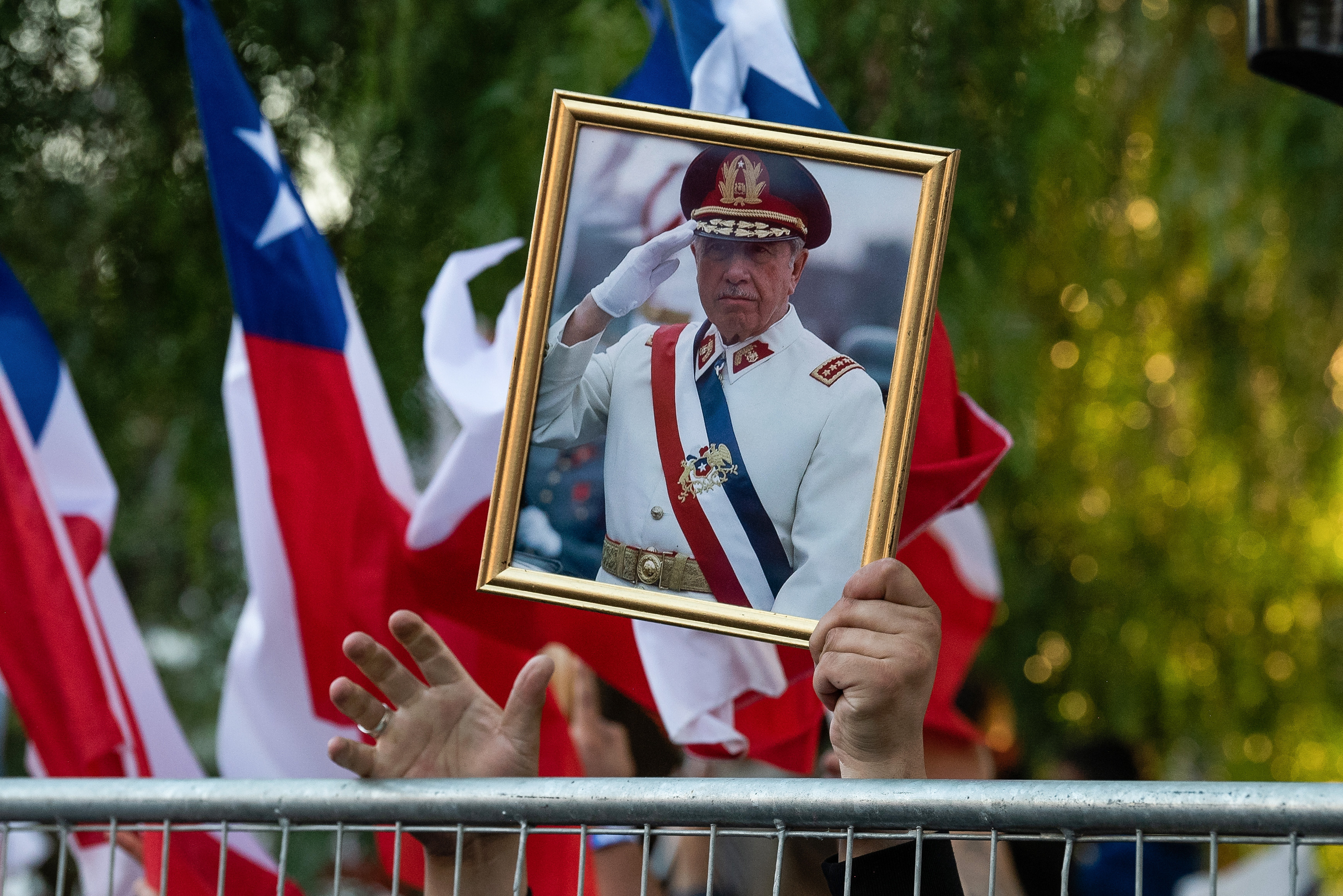 SANTIAGO, CHILE - DECEMBER 14: Supporters of Presidential candidate Jose Antonio Kast of the "Partido Republicano" celebrate with an image of former Chilean President Augusto Pinochet followingg the 2025 presidential election on December 14, 2025 in Santiago, Chile. According to the Chilean electoral institute 'Servel', Kast has 58.21% of the votes against 41.79% for Jeannette Jara of the "Unidad Por Chile" Coalition, after 98.53% of the polling stations counted in the Presidential election runoff.(Photo by Claudio Santana/Getty Images)