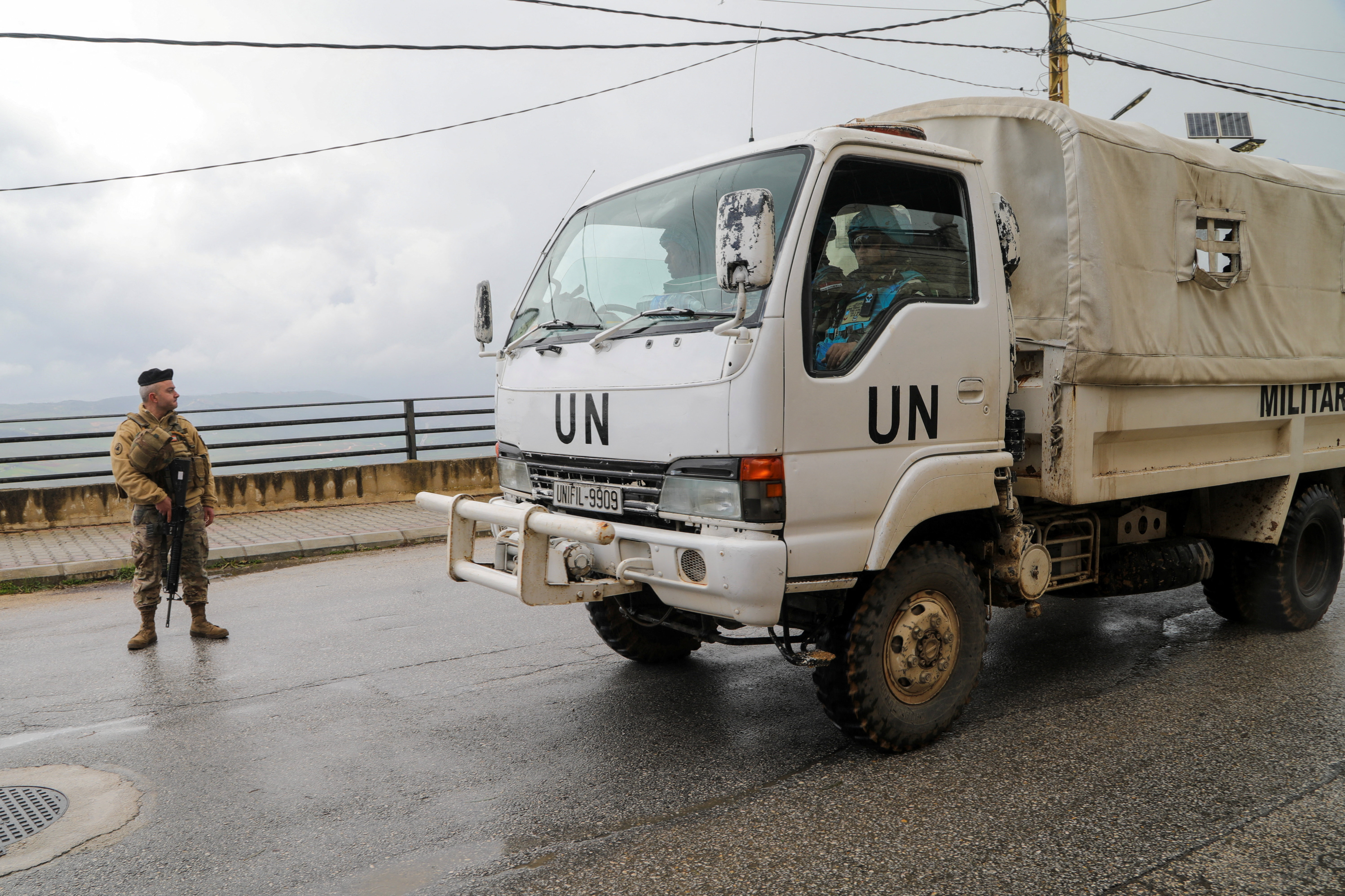 A UNIFIL vehicle drives past a Lebanese soldier, amid escalating hostilities between Israel and Hezbollah, as the U.S.-Israel conflict with Iran continues, in Qlayaa, southern Lebanon, March 27, 2026. REUTERS/Karamallah Daher