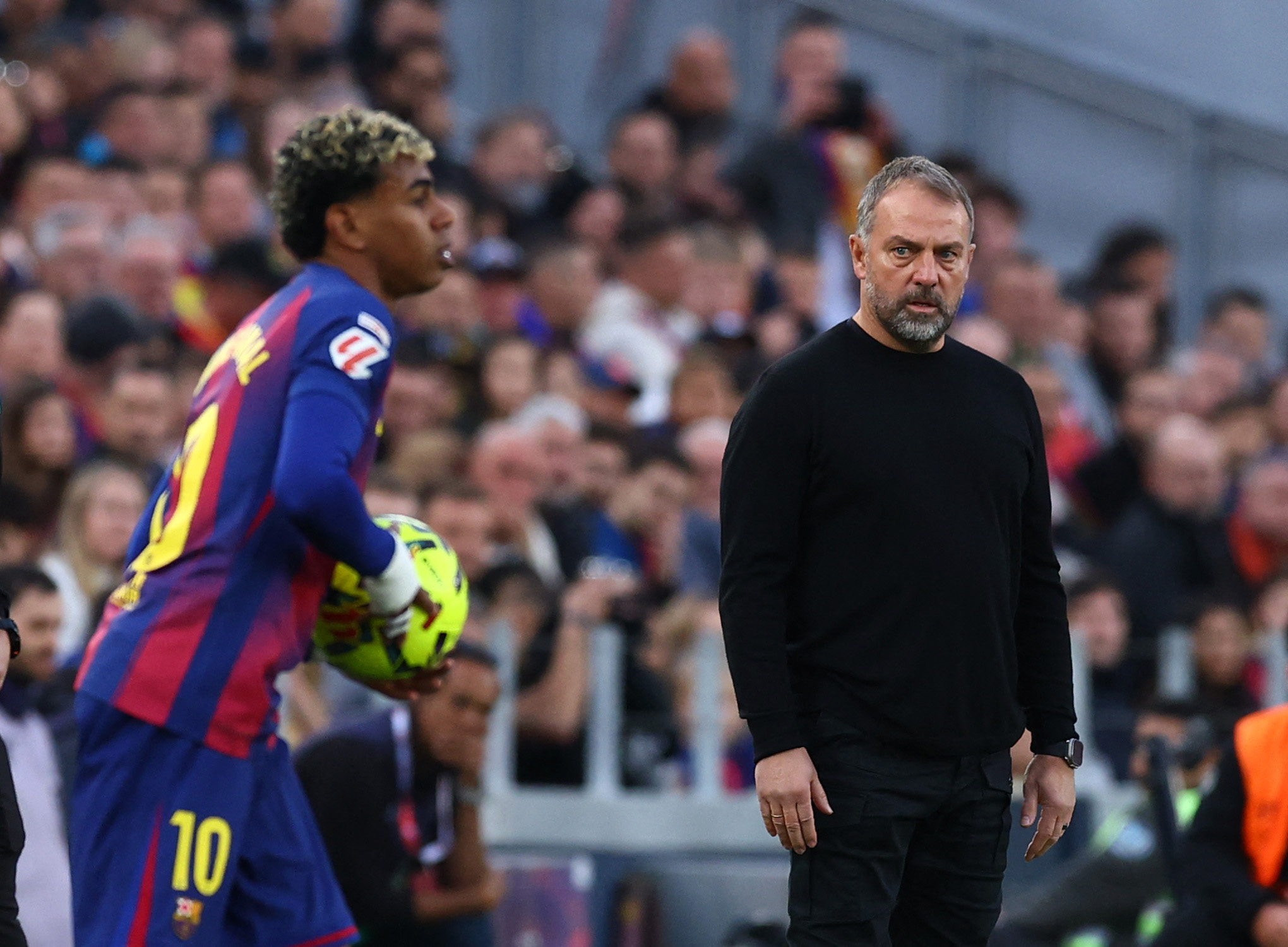 Barcelona coach Hansi Flick looks on as Lamine Yamal holds the ball