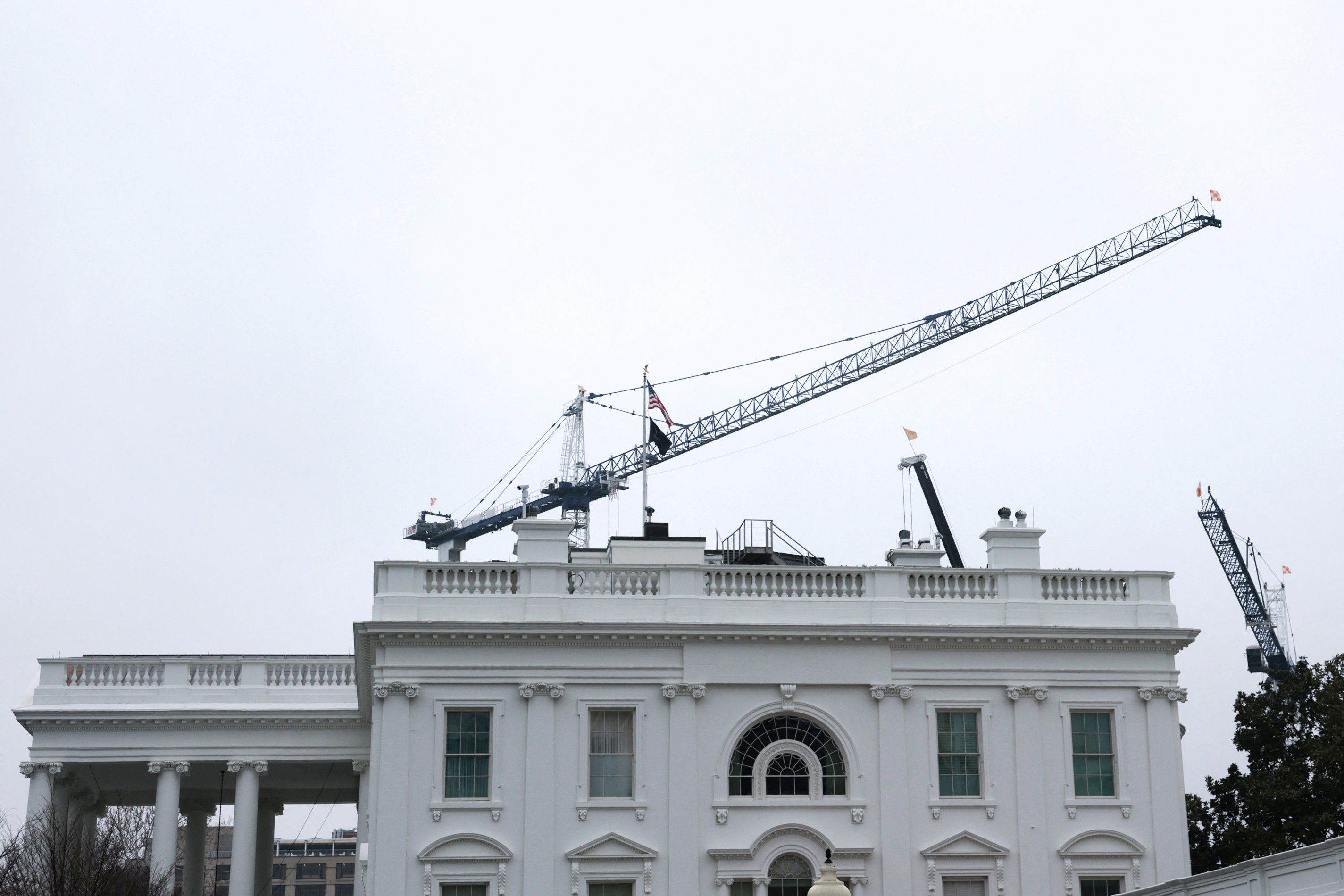 Construction cranes work on U.S. President Donald Trump’s ballroom project overtop the White House