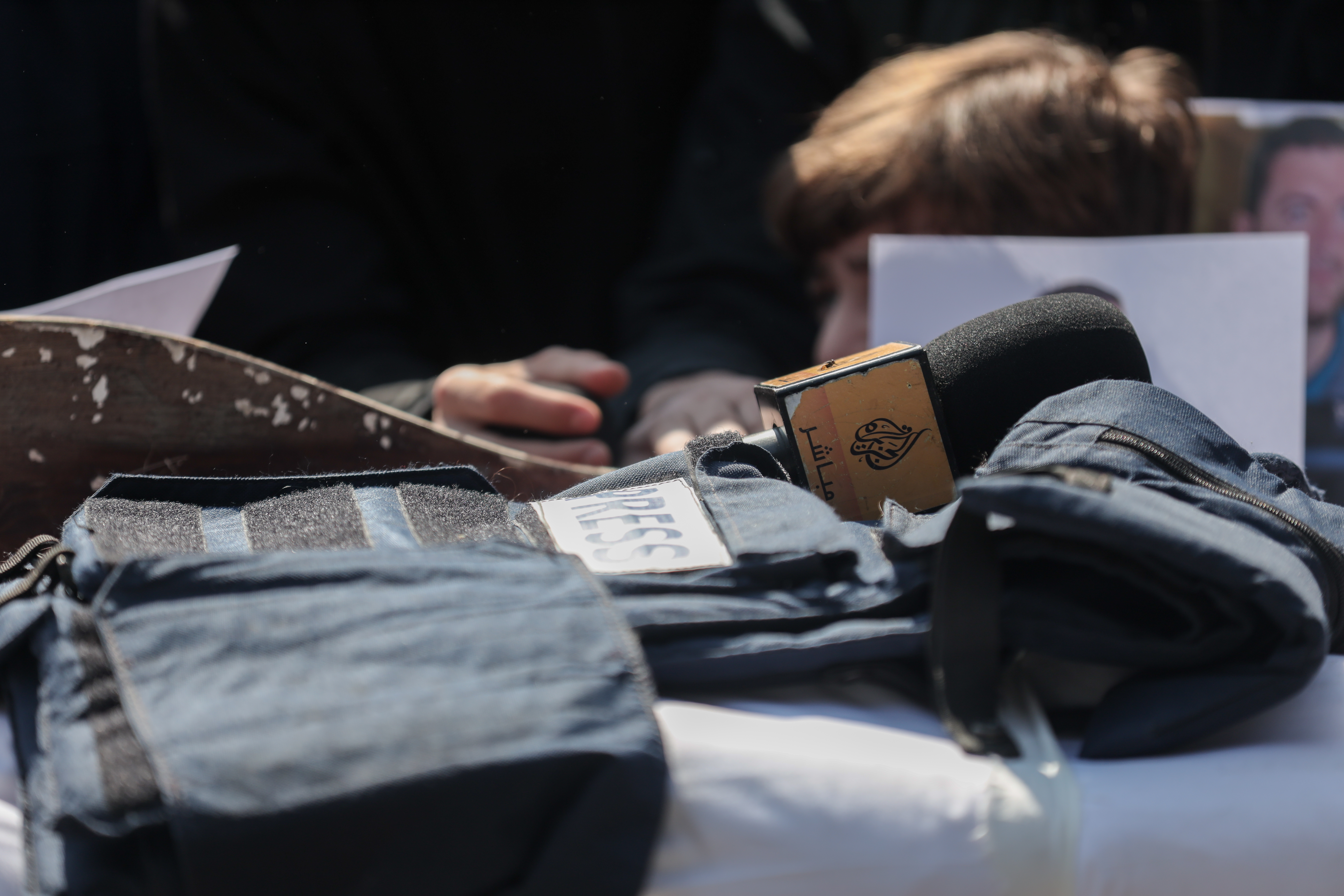 Al Jazeera microphone and a press vest lie on top of Mohammed Wishah's body