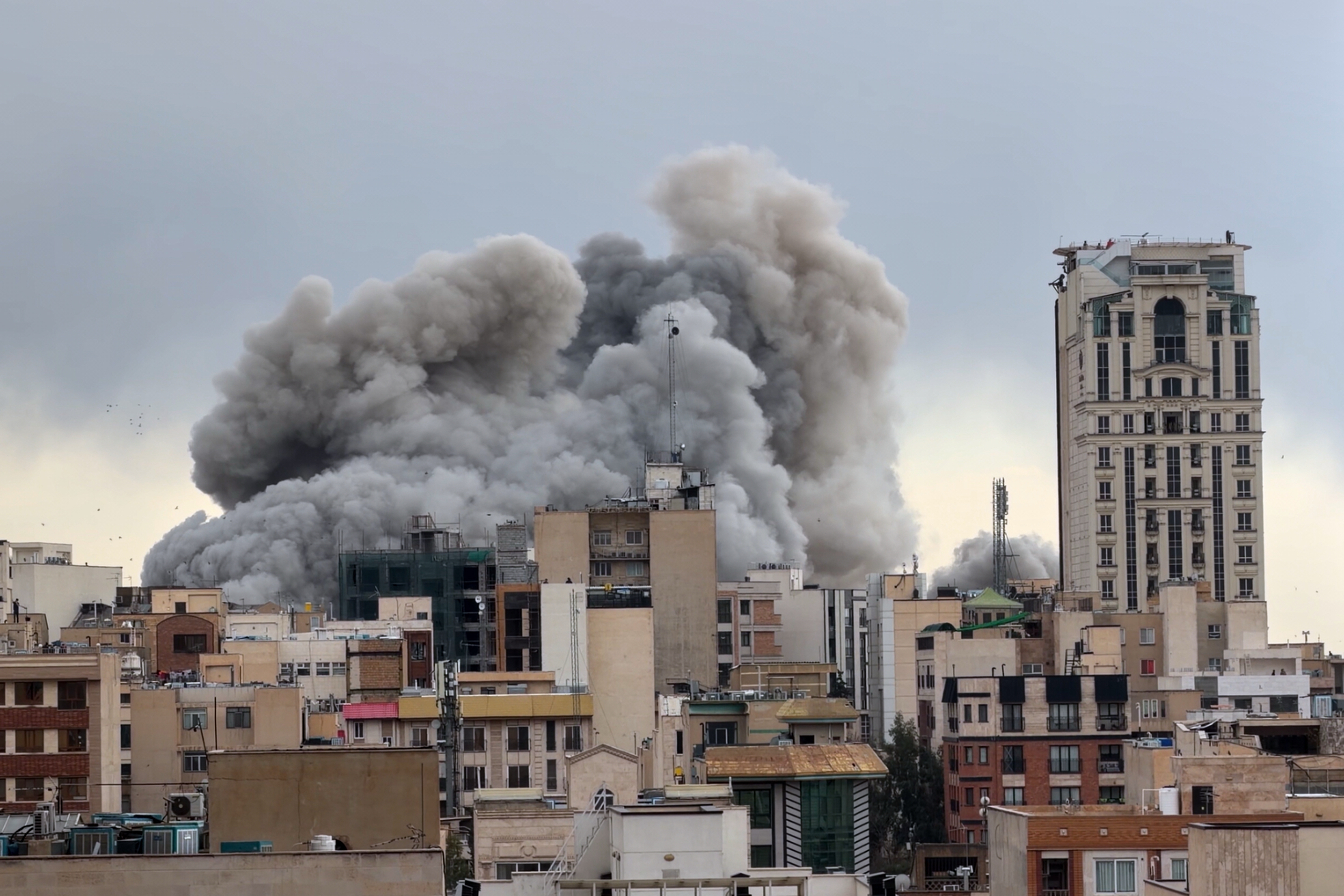 A plume of smoke rises above buildings in Tehran