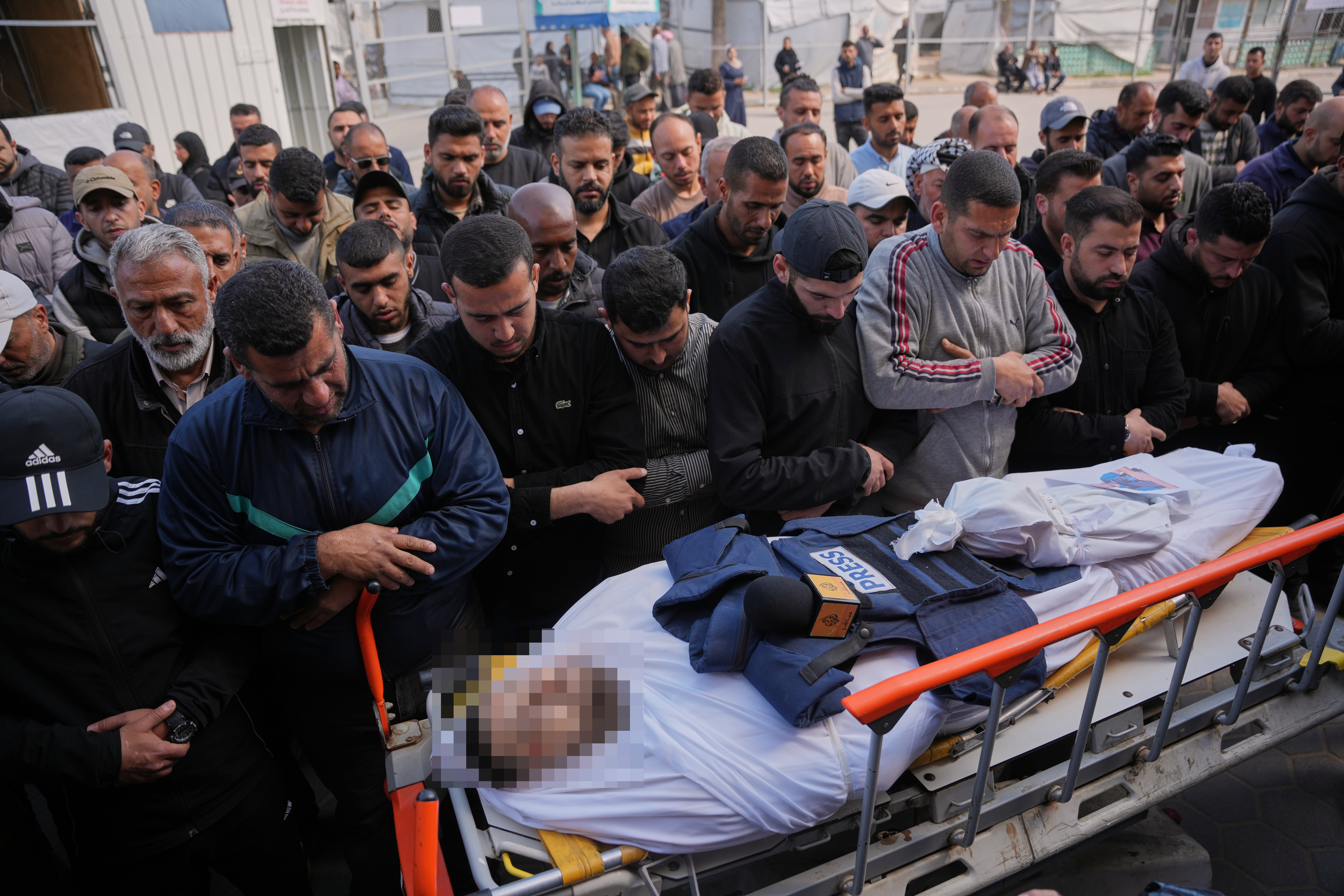 Palestinians pray over the body of Al Jazeera correspondent Mohammed Wishah, who was killed in an Israeli strike on his vehicle, during his funeral outside Al-Aqsa Hospital in Deir al-Balah, central Gaza Strip, Thursday, April 9, 2026. (AP Photo/Abdel Kareem Hana)