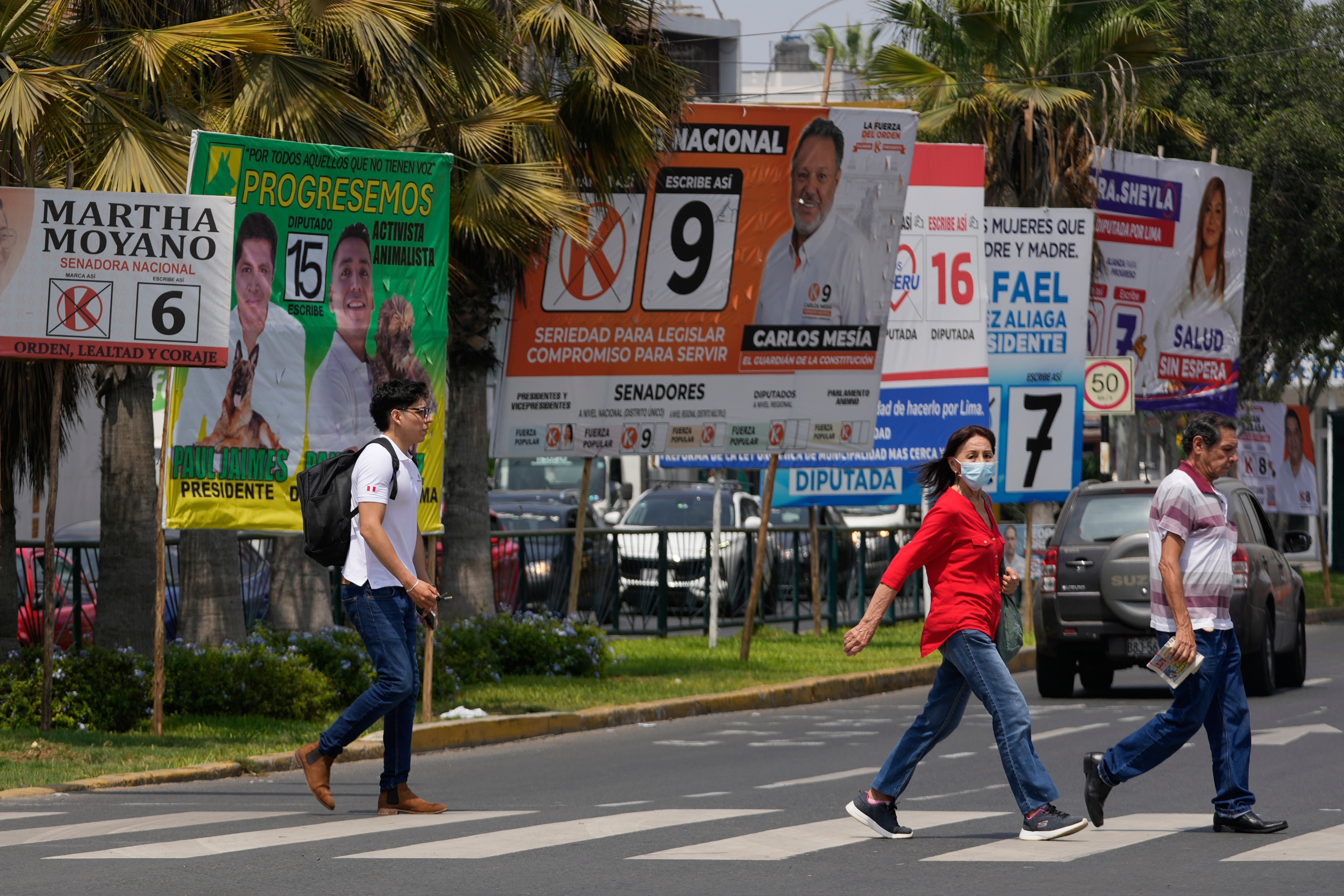 Pedestrians pass election campaign signs for presidential and congressional candidates, before the weekend's election in Lima, Peru, Friday, April 10, 2026. (AP Photo/Martin Mejia)