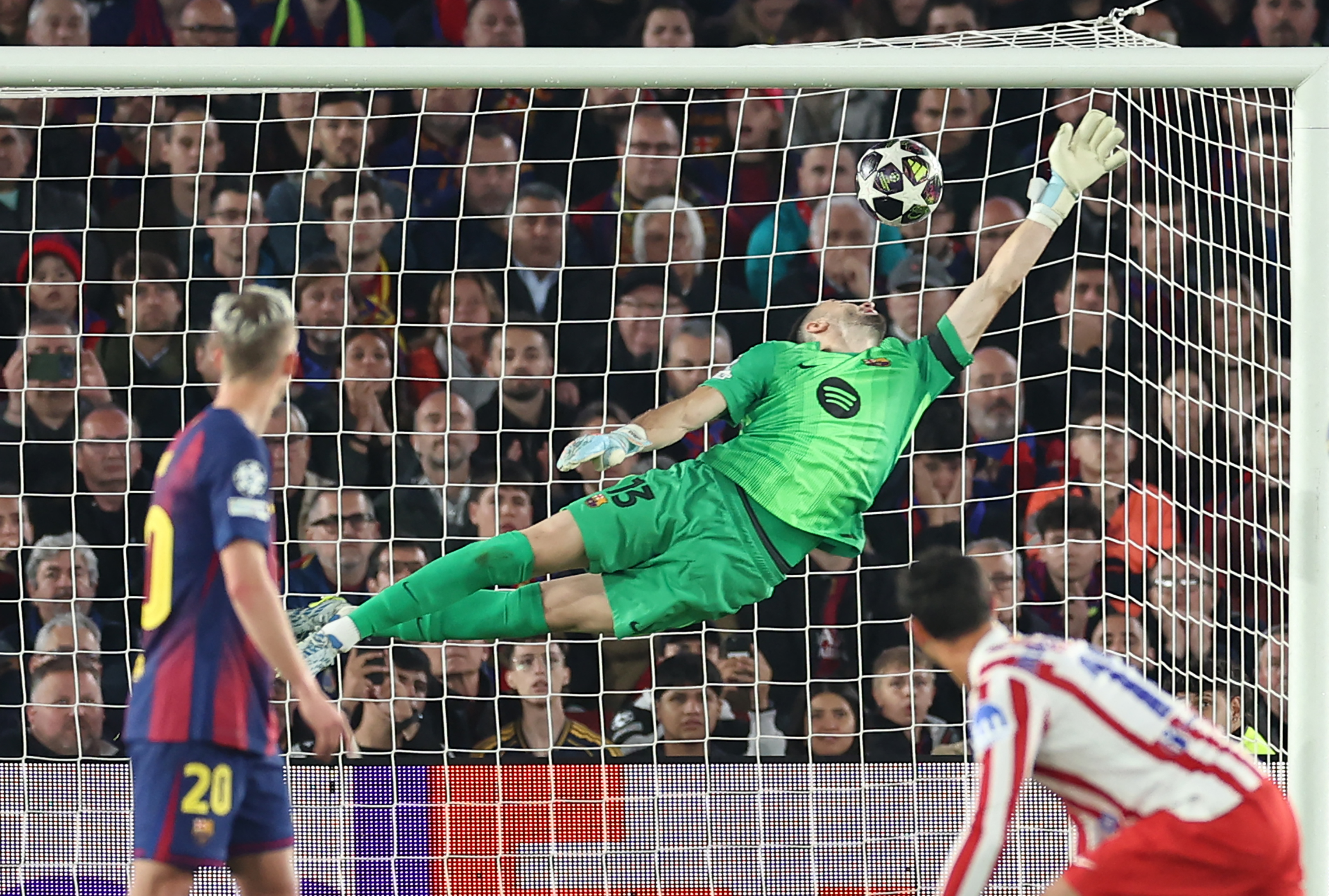 Atletico Madrid's Argentine forward #19 Julian Alvarez (not seen) scores his team's first goal in spite of Barcelona's Spanish goalkeeper #13 Joan Garcia during the UEFA Champions League quarter final first leg football match between FC Barcelona and Club Atletico de Madrid at Camp Nou Stadium in Barcelona on April 8, 2026.