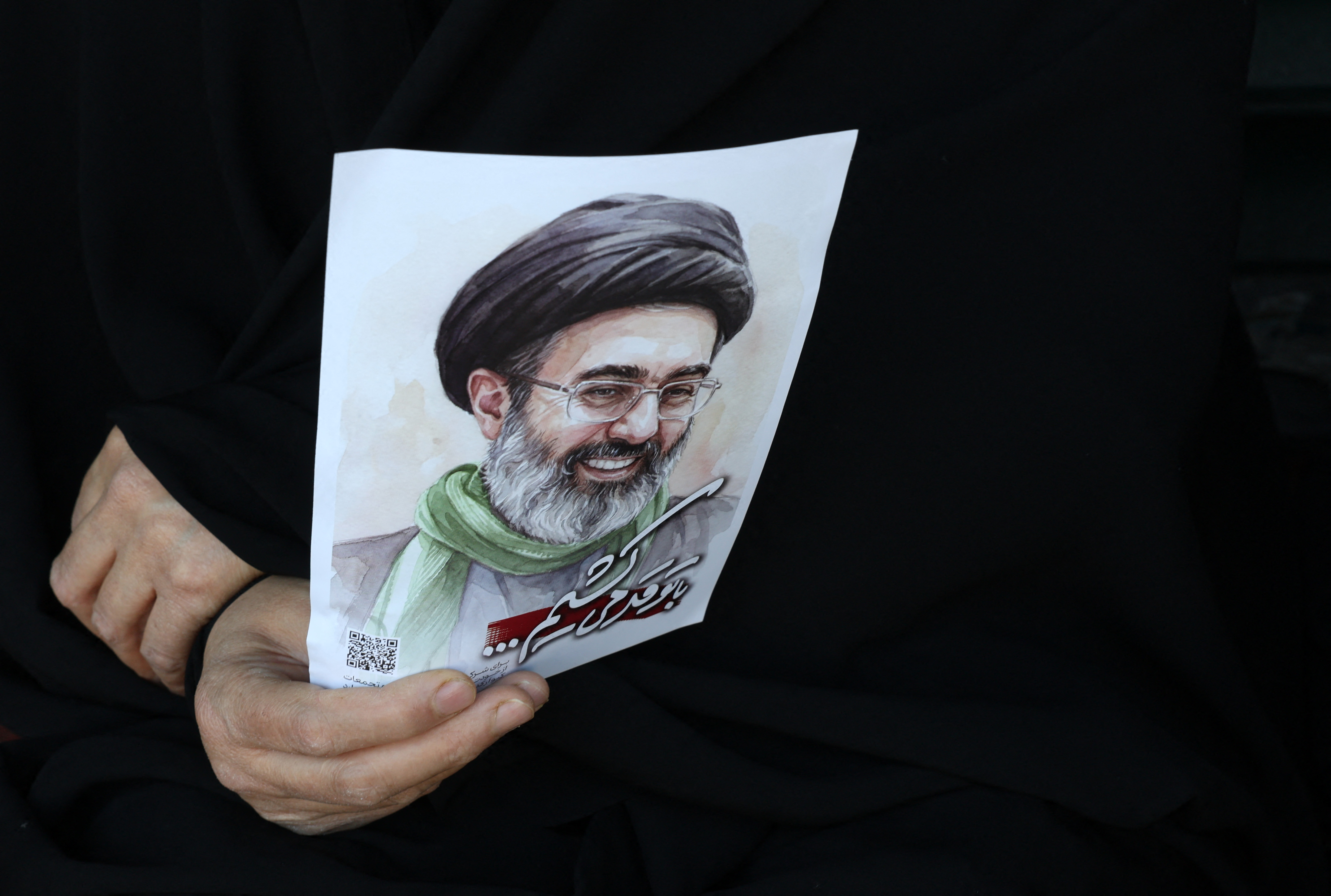 TOPSHOT - A woman holds a portrait of Iran's supreme leader Mojtaba Khamenei during a rally to commemorate the death of his father Iran's slain supreme leader Ayatollah Ali Khamenei in Tehran on April 9, 2026.