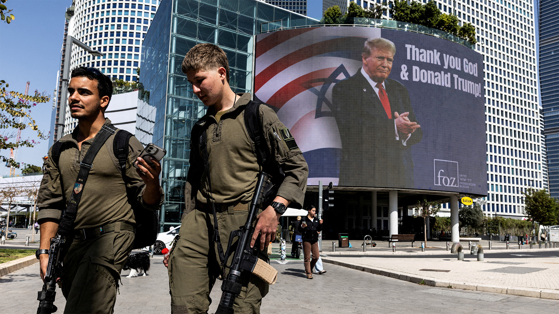 Israeli soldiers walk by a billboard commissioned by an evangelical group, which displays a picture of U.S. President Donald Trump with the words "Thank you God & Donald Trump", amid the U.S.-Israel conflict with Iran, in Tel Aviv, Israel, March 12, 2026.